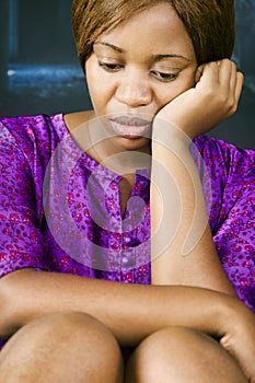 african woman with a sad expression sited on the stairs