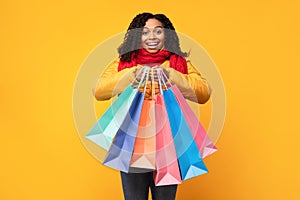 African Woman Shopping In Winter Holding Shopper Bags, Yellow Background