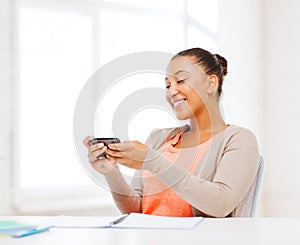 African woman with smartphone in office