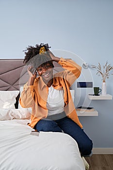 African woman smiling warmly for the camera in her bedroom.