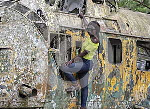 African woman standing on a broken helicopter