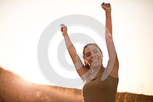 African woman standing in the nature and outstretched arms. Satisfied and happy