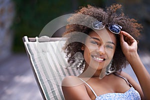 African, woman and sunbathing and relax, holiday for summer on vacation and sunglasses for time fun. Happy, smile or