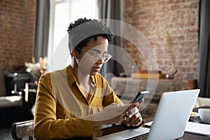 African woman synchronize files between laptop and smartphone use application