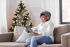 african woman with tablet pc at home on christmas