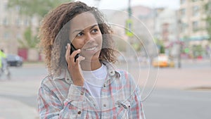 African Woman Talking on Phone while Standing Outdoor