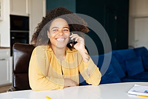 African woman talking on the smartphone at home