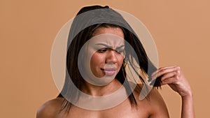 African Woman Touching Dry Hair With Split Ends, Beige Background