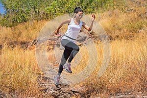 African woman Trail running in Meadow on mountain outdoor. sport adventure . black female runner and   jumping on country path or