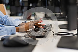 African woman is typing on the keyboard. Close-up of female hands of an office worker.