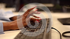 African woman is typing on the keyboard. Close-up of female hands of an office worker.