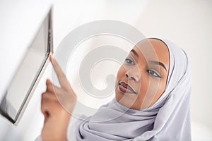 African woman using smart home screen