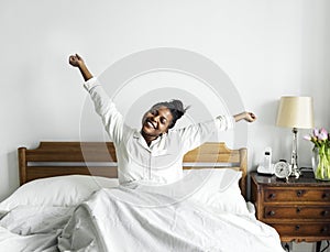 An african woman waking up in bed