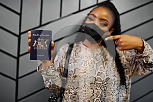 African woman wearing black face mask show Mauritius passport in hand. Coronavirus in Africa country, border closure and