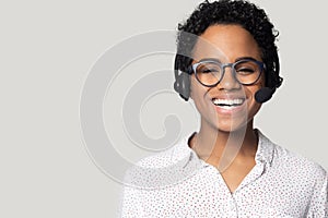 African woman wearing headset with microphone posing isolated on grey