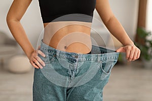 African Woman Wearing Old Large Jeans After Slimming Indoor, Cropped