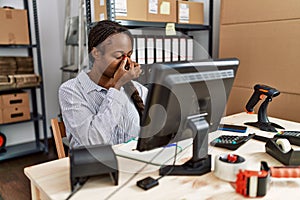 African woman working at small business ecommerce tired rubbing nose and eyes feeling fatigue and headache