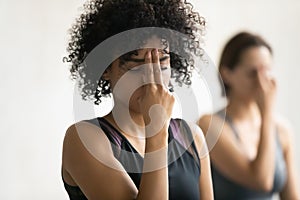 African woman during yoga class do Alternate Nostril Breathing practice