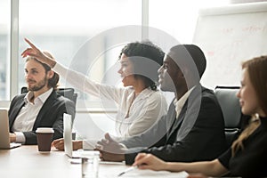 African woman raising hand to ask question at team training photo