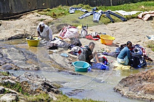 African women washing clothes on a river. Washed clothes are lie