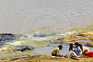African women washing clothes on a river. Washed clothes are lie