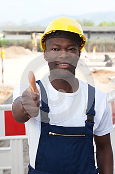 African worker at construction zone showing thumb up