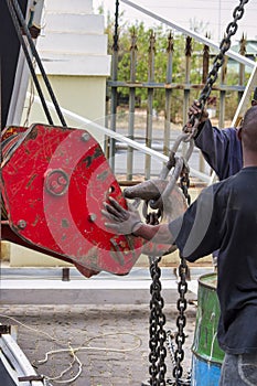 african worker securing a crane hook