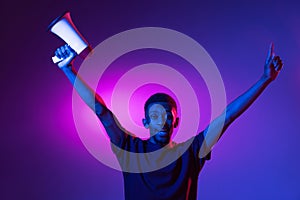 African young man isolated on blue studio background in neon. Concept of human emotions, facial expression.