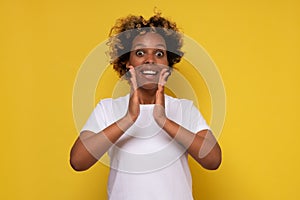 African young woman clasping hands in applause, saying wow