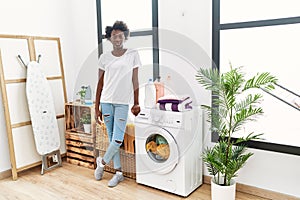 African young woman doing laundry at home thinking attitude and sober expression looking self confident