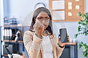 African young woman holding smartphone showing blank screen annoyed and frustrated shouting with anger, yelling crazy with anger