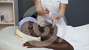 African young woman during massage in the spa salon.
