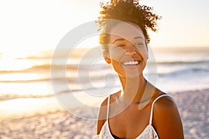 African young woman relaxing at beach during sunset