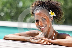 African young woman relaxing on swimming pool edge