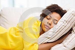 African young woman sleeping on sofa at home