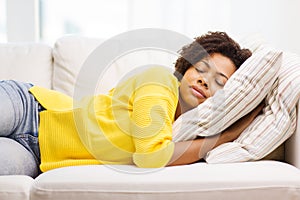 African young woman sleeping on sofa at home