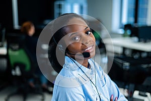 African young woman talking to a client on a headset. Female employee of the call center.