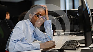 African young woman typing on a computer at her desk in the office.