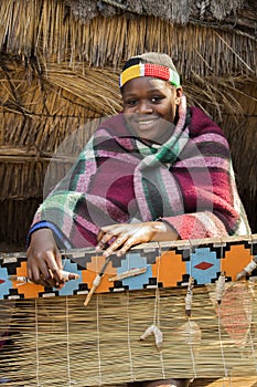 African Zulu woman weaves straw carpet.