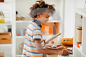 Afro-American boy cooking gingerbread cookies