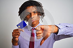 Afro american businessman with dreadlocks holding credit card over isolated white background with angry face, negative sign