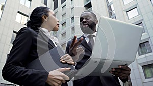 Afro-American businessman giving instructions to assistant, working on project