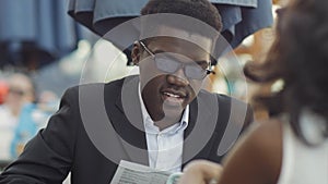 Afro-american businessman with his colleague reading menu in restaurant