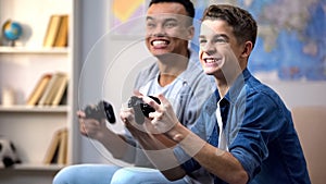 Afro-american and caucasian boys happy to win video game leisure time activity