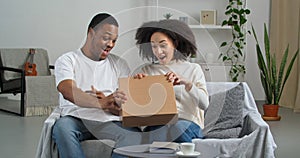 Afro american couple black husband and wife consumers buyers receive parcel by mail from internet store with interest