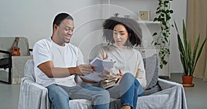 Afro american couple young family sitting on couch quarreling over documents received letter from bank husband learns