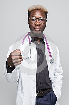 Afro american Doctor holding pills in hands isolated on gray background