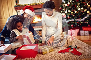 Afro American family in Christmas morning opening present