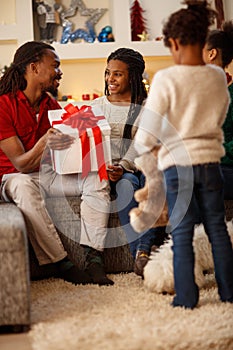 Afro-American family with gift for Christmas at home