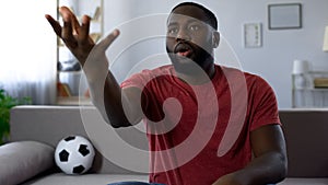 Afro-american fan criticizing game of players, football expert, bad result